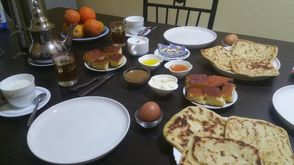 une table avec des assiettes de nourriture, des œufs et du pain dans l'établissement Takad Dream Rural, à El Borj