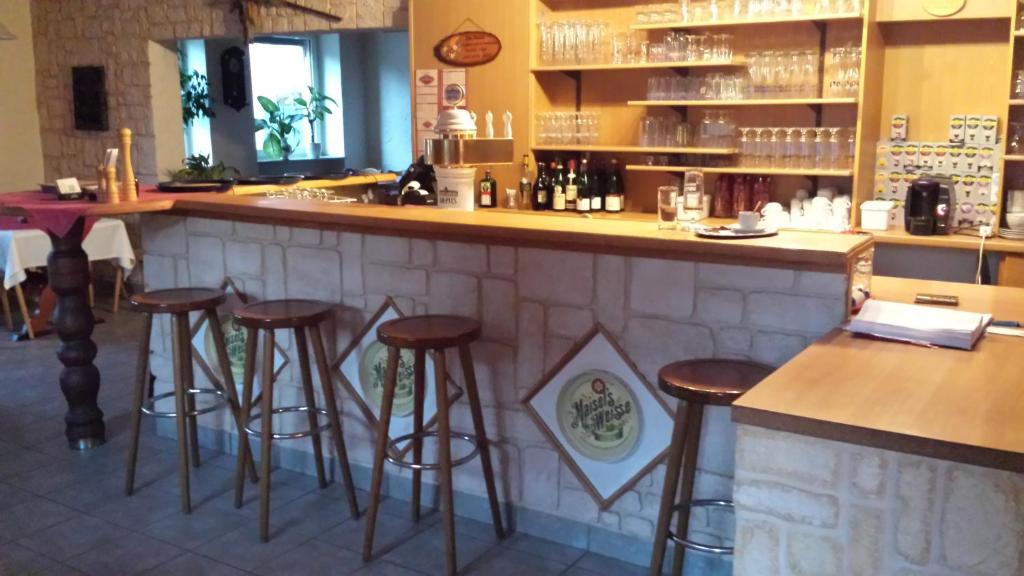 un bar en un restaurante con taburetes en Zum-Altbreitenfelderhof, en Altbreitenfelderhof