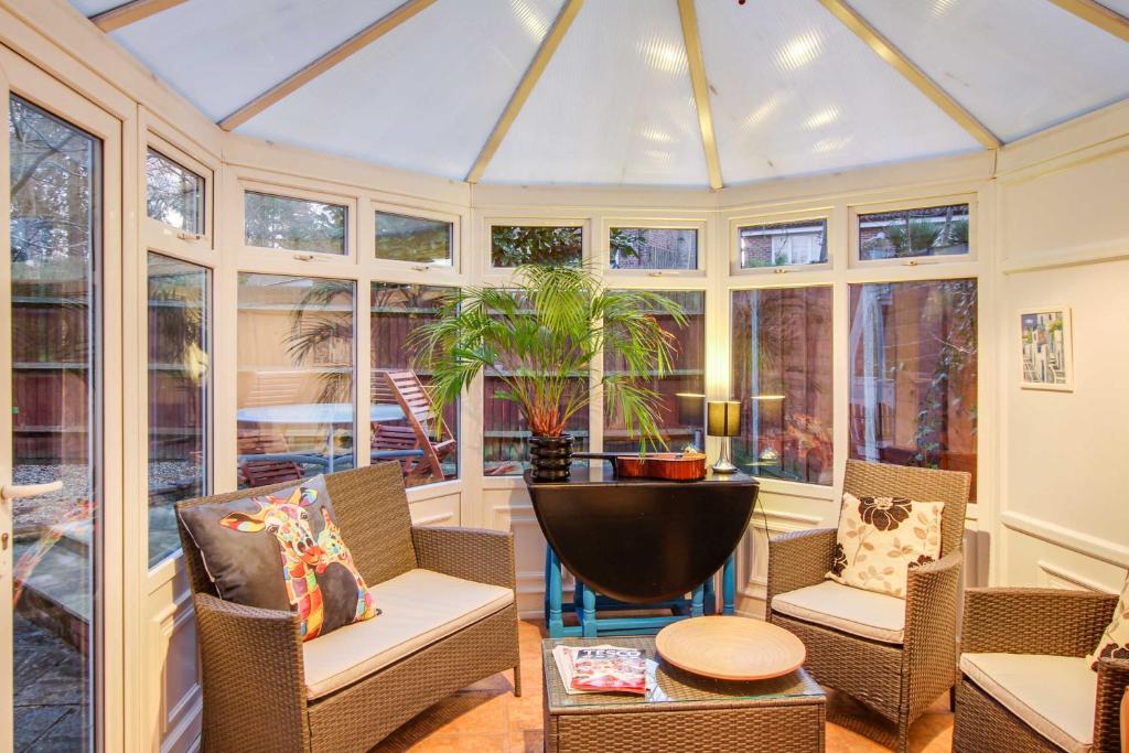 a conservatory with chairs and a table and windows at The Marlborough in Crawley