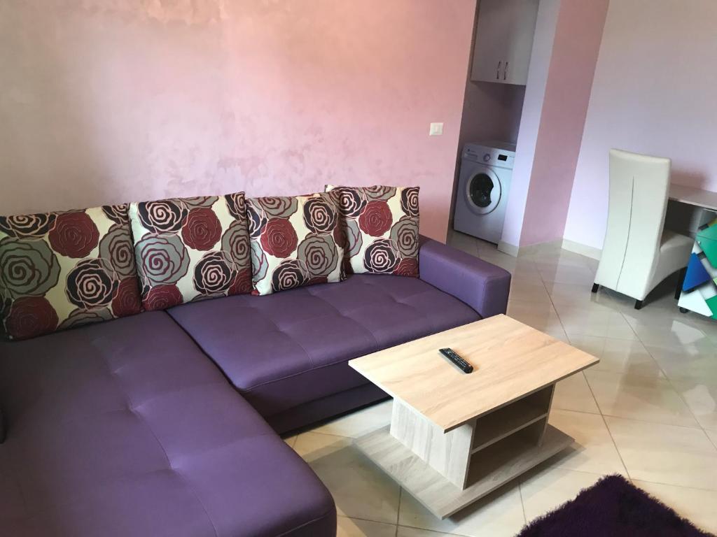 a living room with a purple couch and a coffee table at KM 0 Residence in Piatra Neamţ