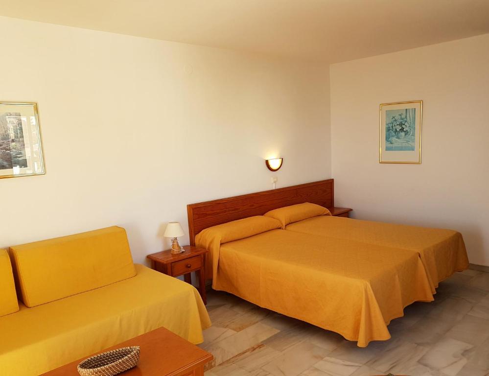 a hotel room with two beds and a couch at Sunny Beach in Benalmádena