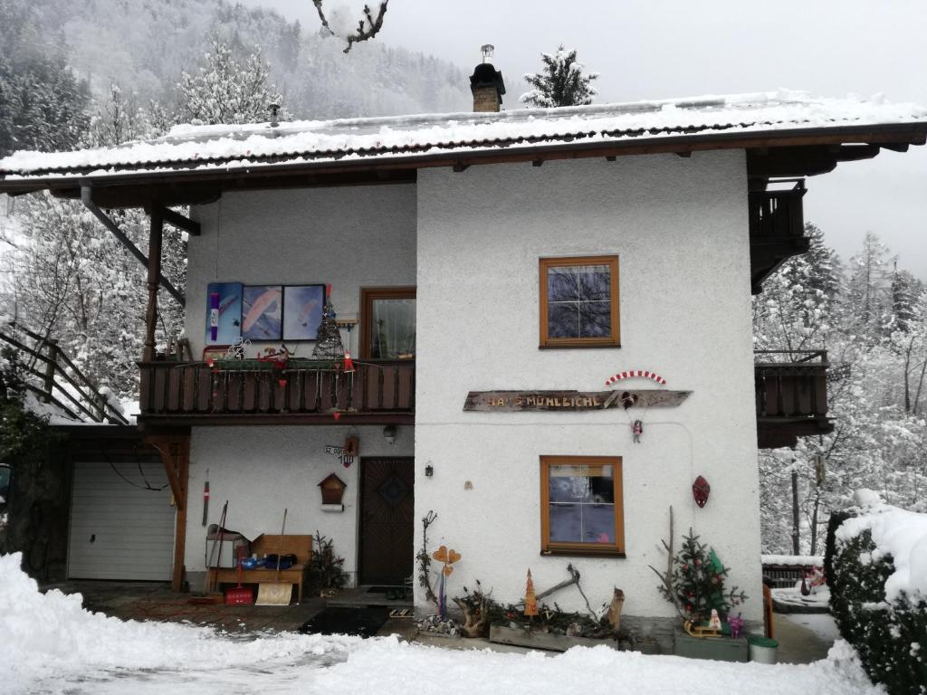 ein weißes Haus mit Balkon im Schnee in der Unterkunft Haus Mühlbichl in Finkenberg