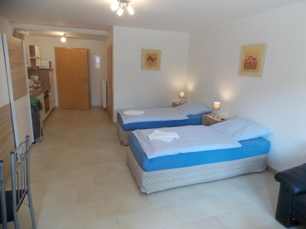 um quarto com duas camas num quarto com um corredor em Angelhof Weseloh em Karolei
