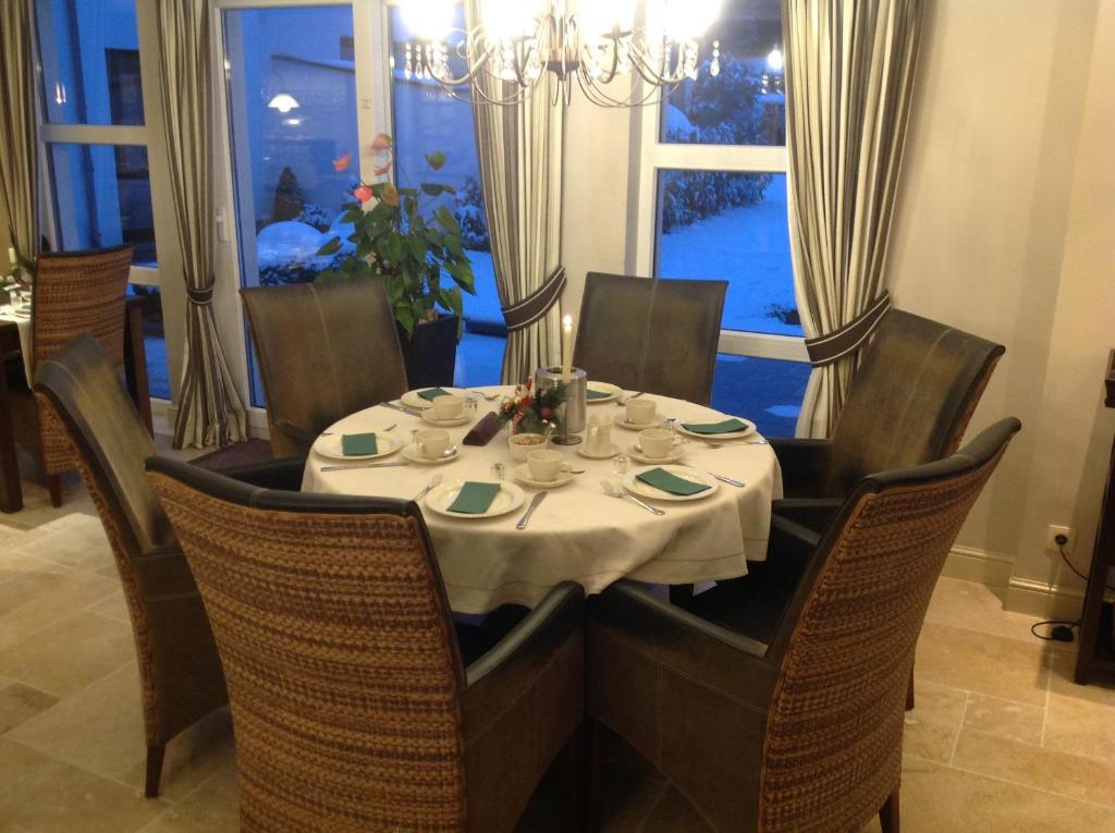 a dining room table with a white table cloth on it at Hotel Eifelland in Butgenbach