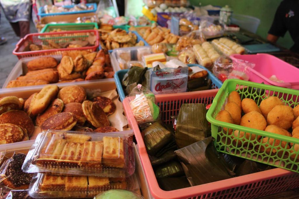 a display of different types of food in plastic trays at Rumah Pathuk Syariah Homestay in Yogyakarta