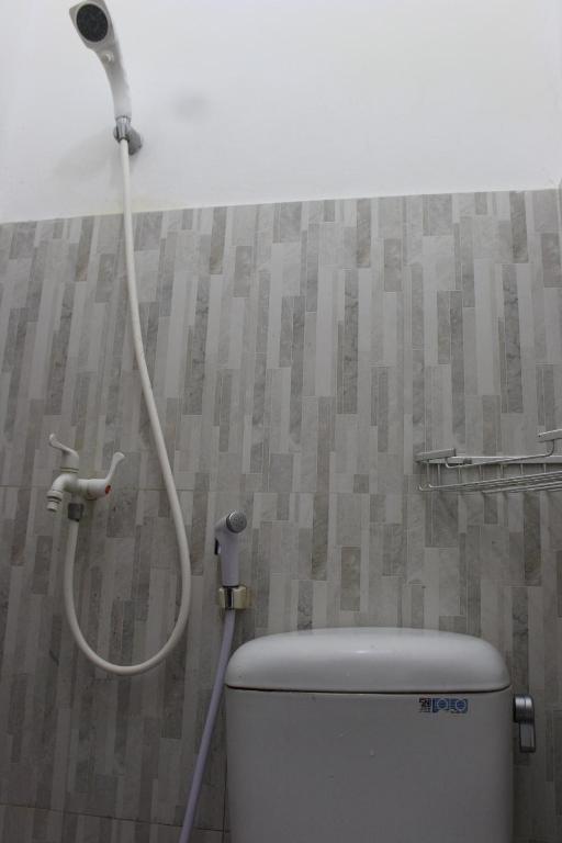 a shower in a bathroom with a toilet at Rumah Pathuk Syariah Homestay in Yogyakarta