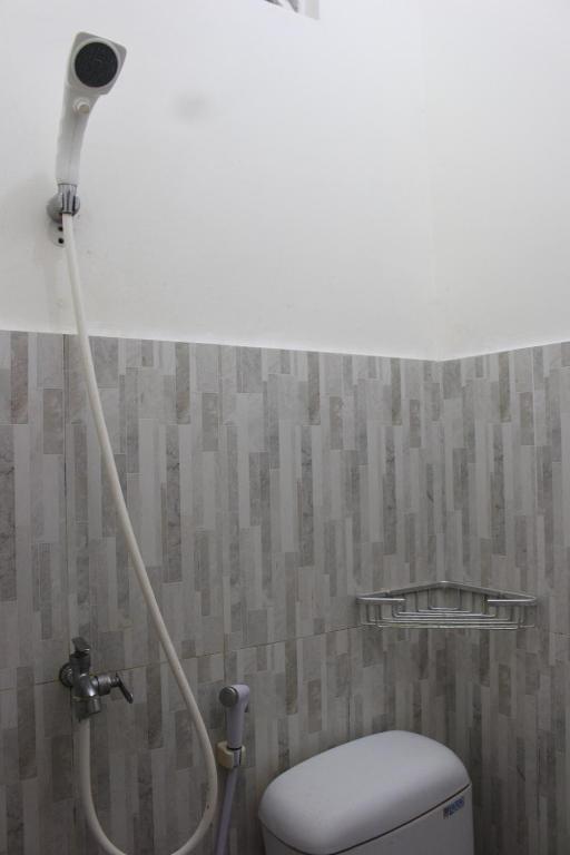 a shower in a bathroom with a toilet at Rumah Pathuk Syariah Homestay in Yogyakarta