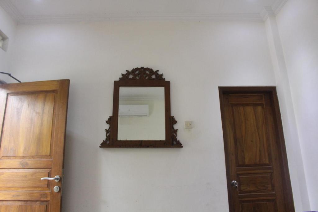 a mirror on a wall next to a door at Rumah Pathuk Syariah Homestay in Yogyakarta