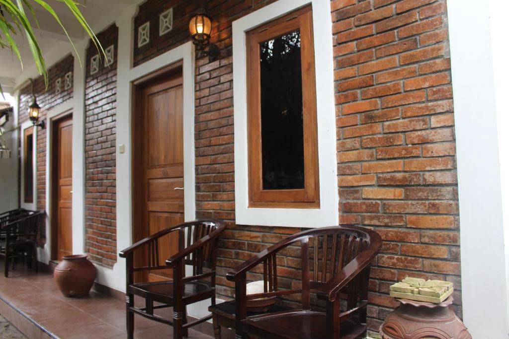 a porch with two chairs and a brick wall at Rumah Pathuk Syariah Homestay in Yogyakarta