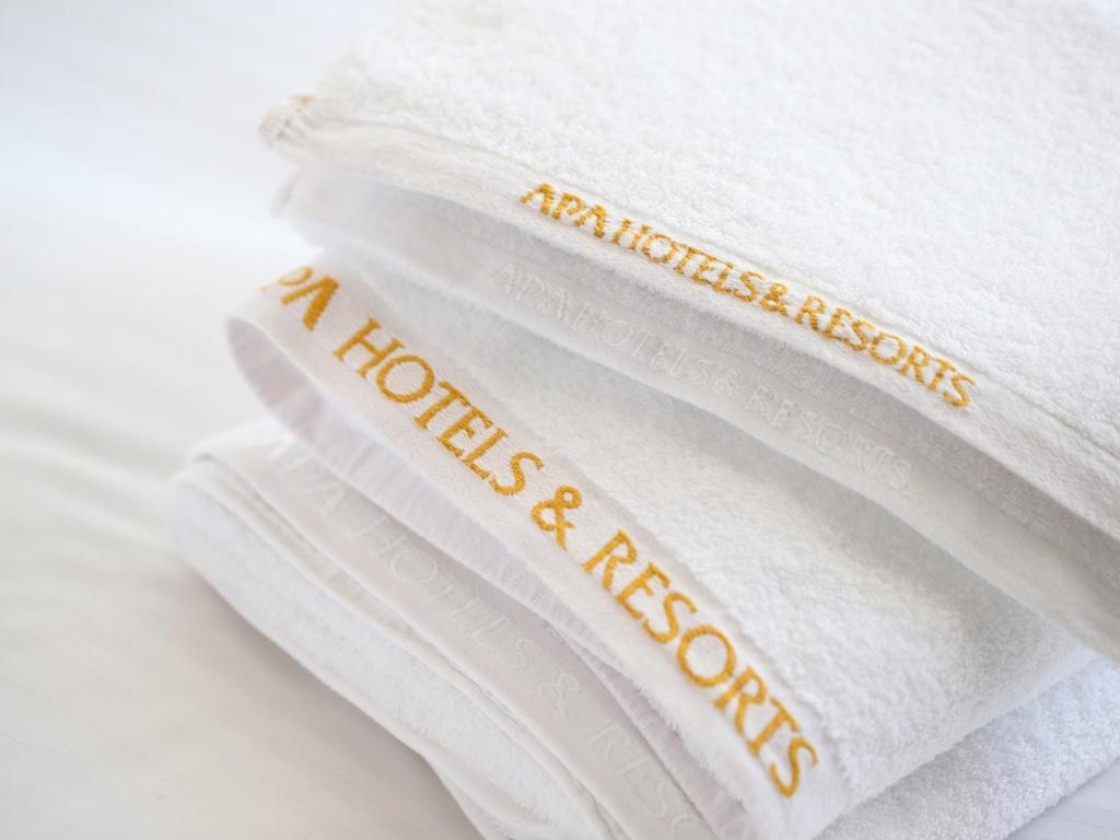 a stack of white towels with the words mattress inspections on them at APA Hotel Ningyocho Ekikita in Tokyo