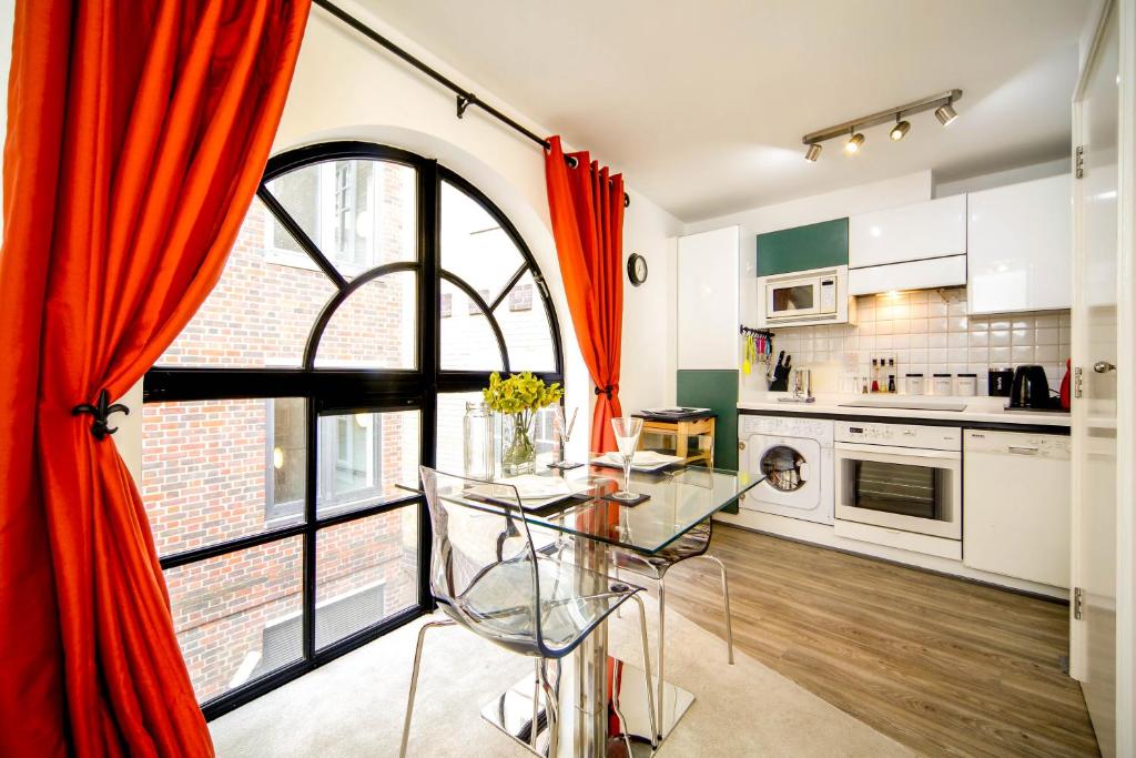 eine Küche mit einem Glastisch und einem großen Fenster in der Unterkunft Exclusive 1 Bed Flat Close To St Paul's Cathedral in London