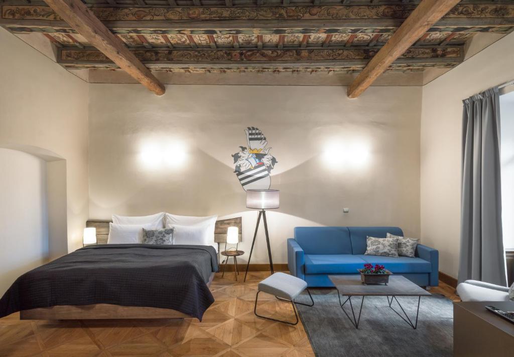 una camera con un letto blu e un divano blu di 3 Epoques Apartments by Adrez a Praga