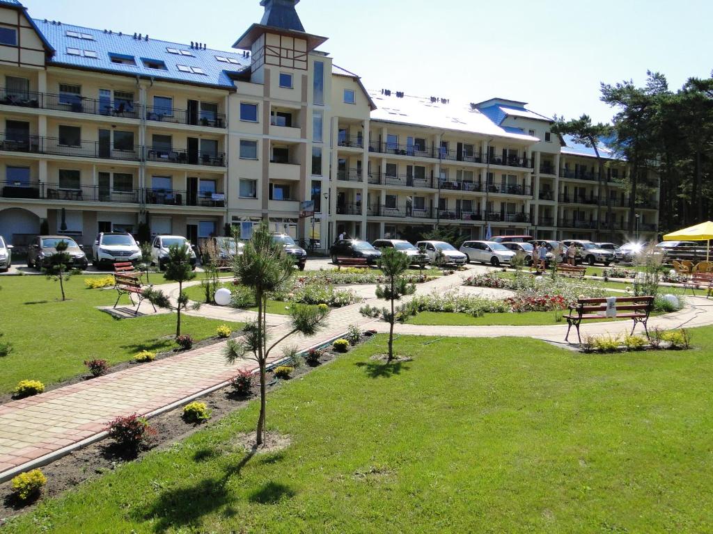 a large building with a park in front of it at Bursztyn Blu Mare in Łukęcin