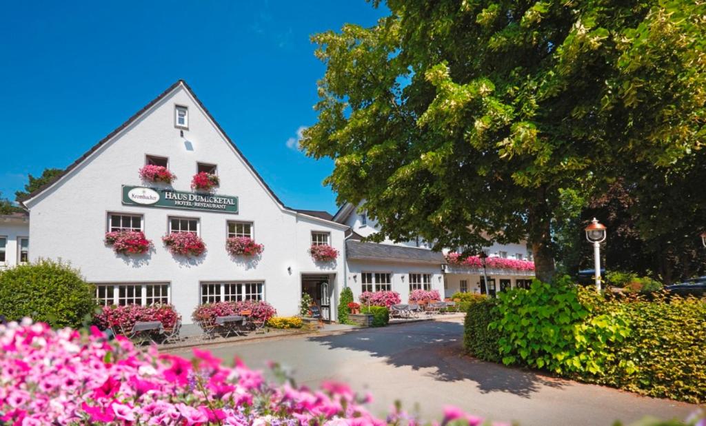 een wit gebouw met bloemen ervoor bij Haus Dumicketal in Drolshagen