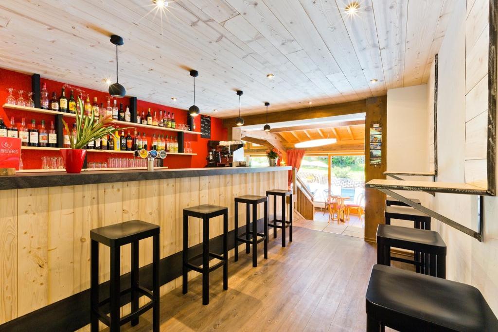 a bar with black stools in a restaurant at Hotel Les Bruyères in Morzine