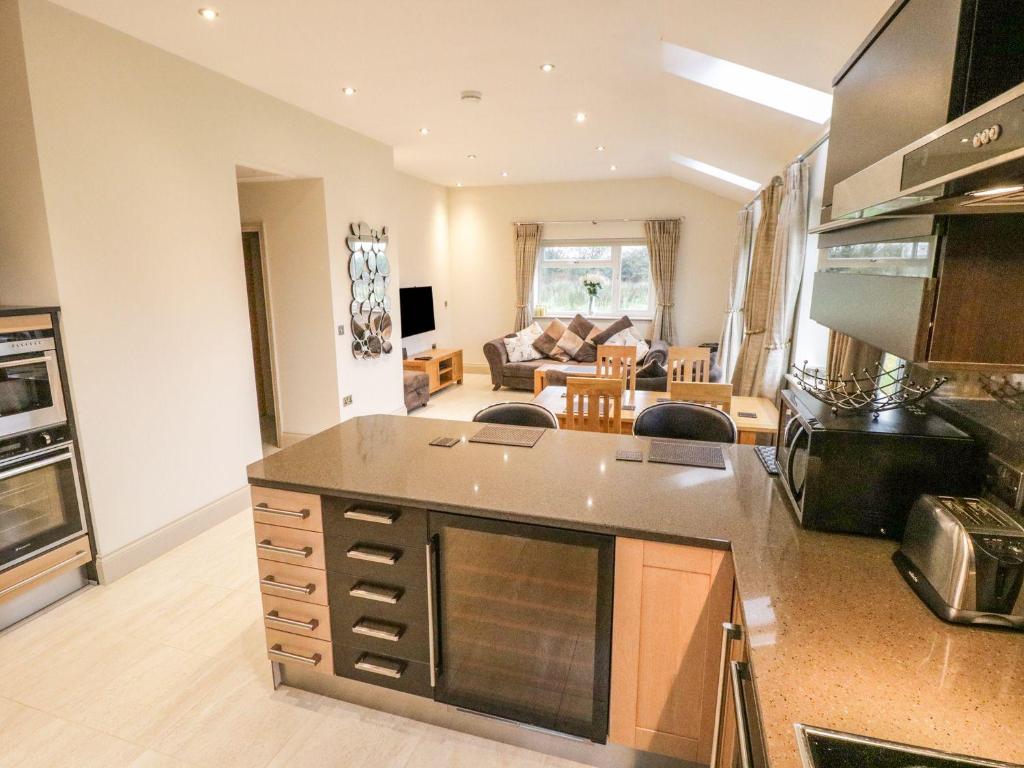 a kitchen and living room with a stove top oven at Shreyas Cottage in Blackburn