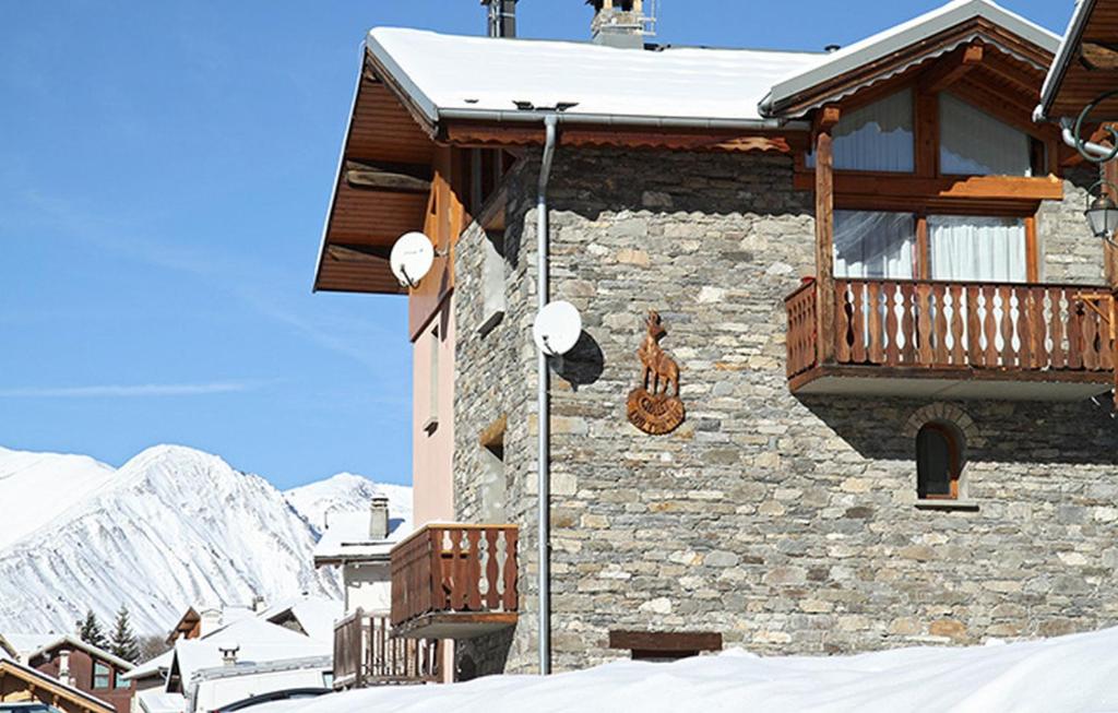 a building with a balcony in the snow at Odalys Chalet Loutantin in Saint-Martin-de-Belleville