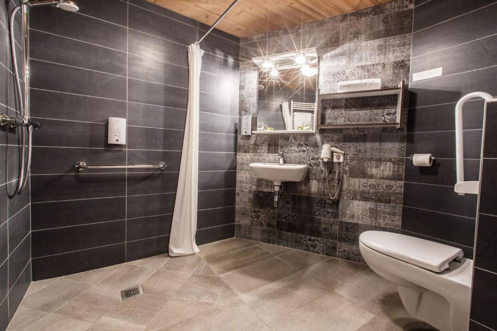 a bathroom with a toilet and a sink at Hotel Les Bruyères in Morzine