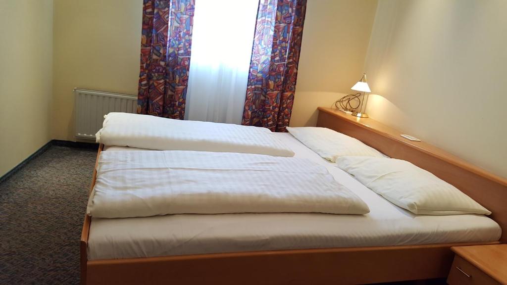 Postel nebo postele na pokoji v ubytování CenterCourt Hotel
