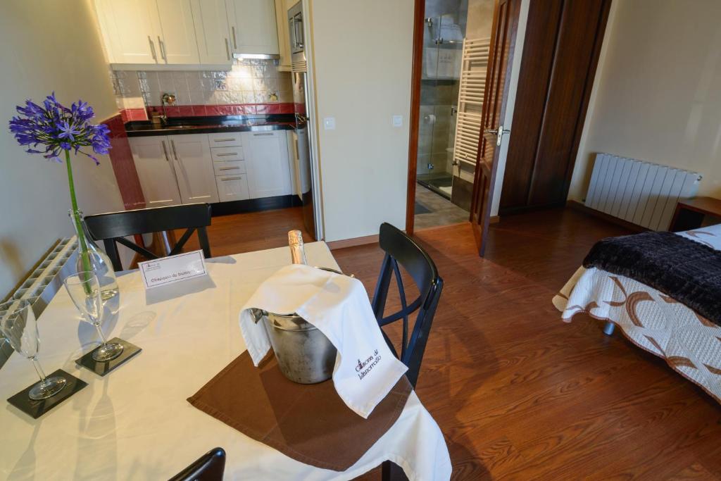 a dining room table with a vase of flowers on it at Casona de Llanorrozo Apartamentos Rurales in Oviñana