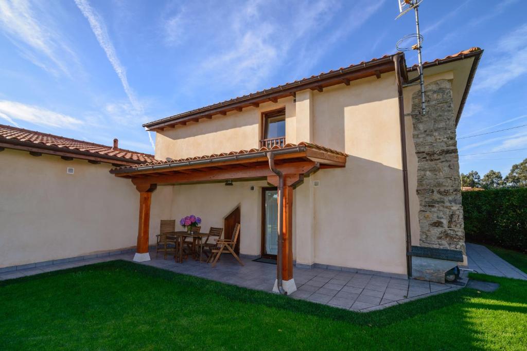an external view of a house with a patio at Casona de Llanorrozo Apartamentos Rurales in Oviñana