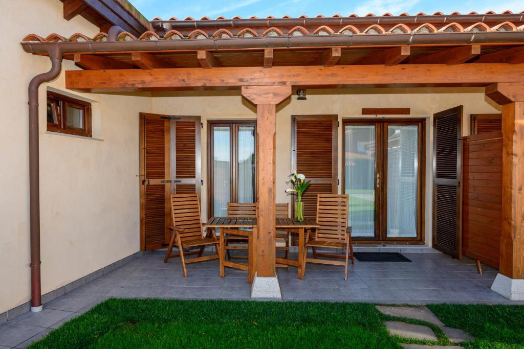 a patio with a wooden pergola with a table and chairs at Casona de Llanorrozo Apartamentos Rurales in Oviñana