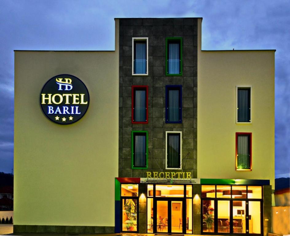 um edifício de hotel com uma placa na lateral em Hotel Baril em Hateg