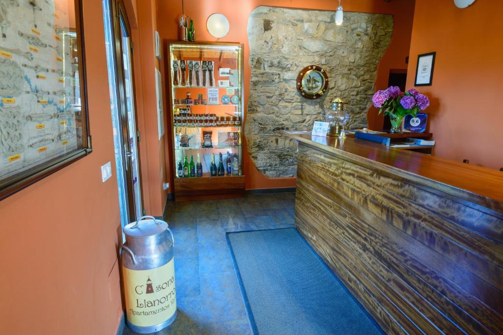 a bar in a restaurant with a counter and a counter at Casona de Llanorrozo Apartamentos Rurales in Oviñana