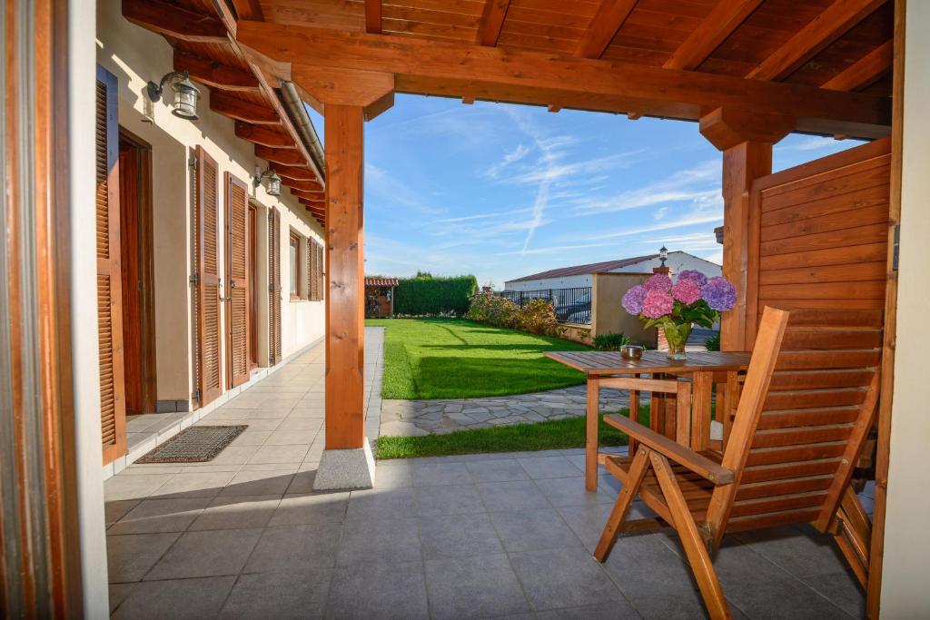 a patio with a wooden table and a bench at Casona de Llanorrozo Apartamentos Rurales in Oviñana