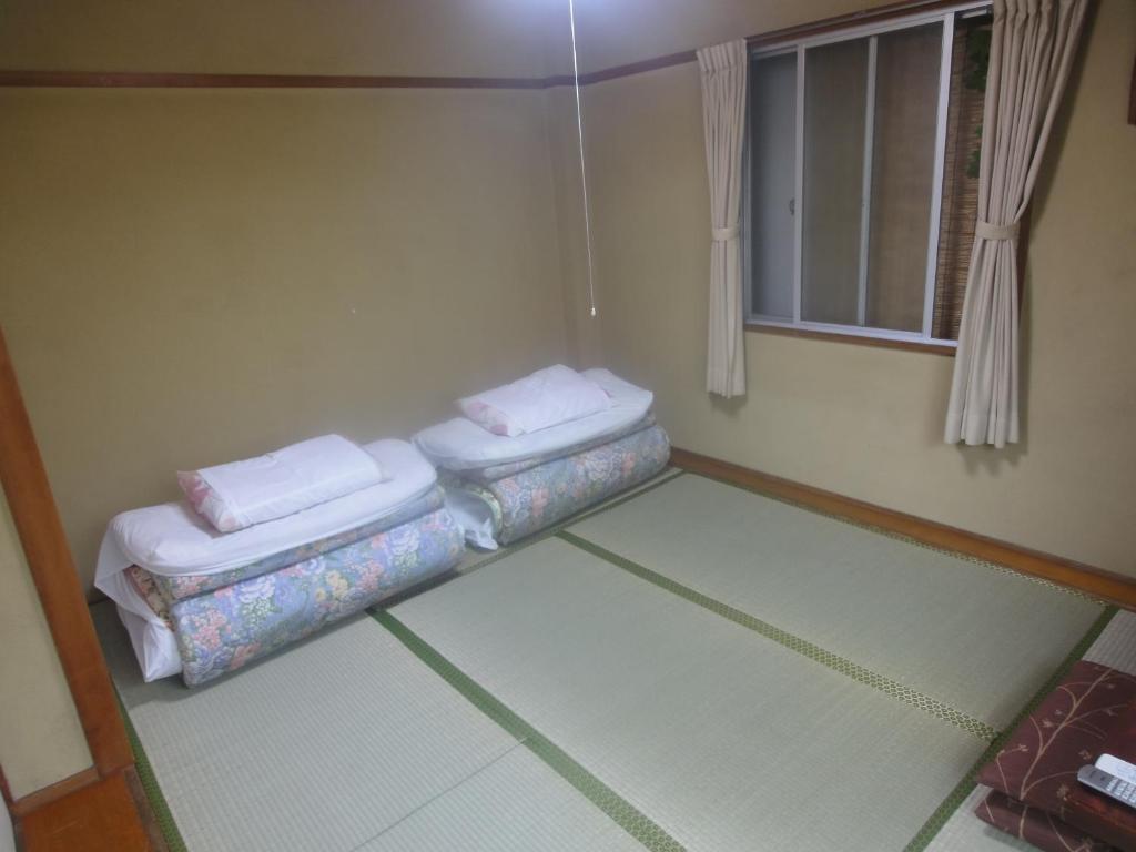 Postel nebo postele na pokoji v ubytování Kasuga Ryokan