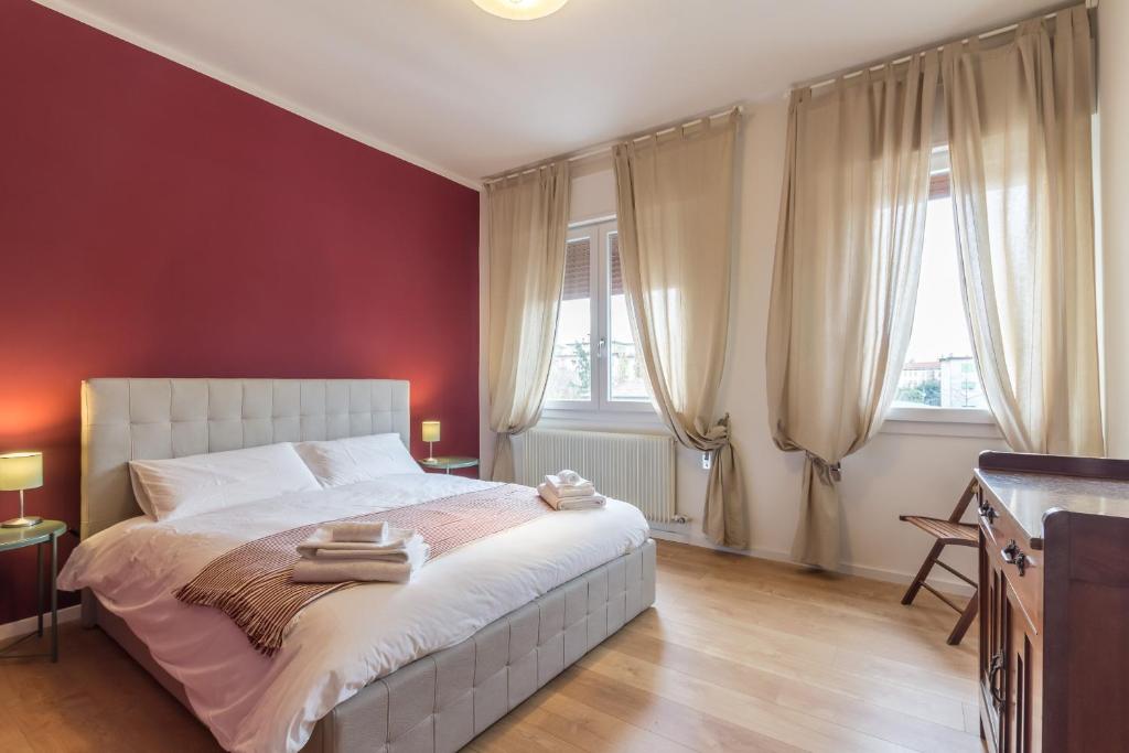 a bedroom with a bed with red walls and windows at Casa Stretti by Welc(H)ome in Treviso