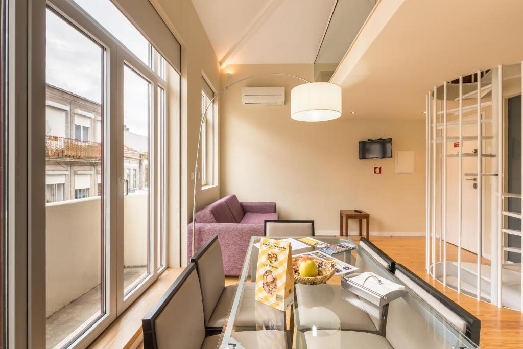 sala de estar con mesa de cristal y sofá púrpura en PATH Porto Apartments, en Oporto