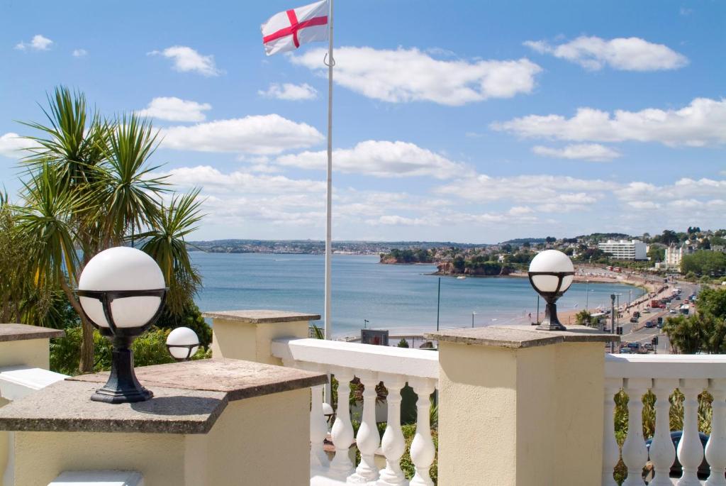 a view of the ocean from a balcony with a flag at The Heritage Hotel in Torquay