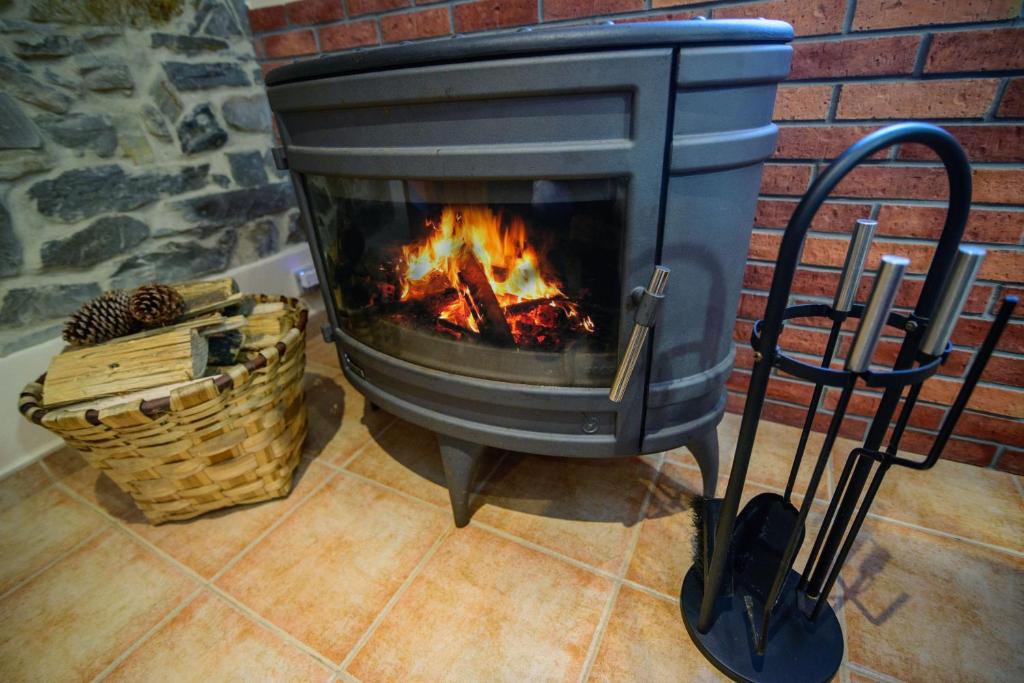 a fireplace sitting next to a brick wall at Casona de Llanorrozo Apartamentos Rurales in Oviñana