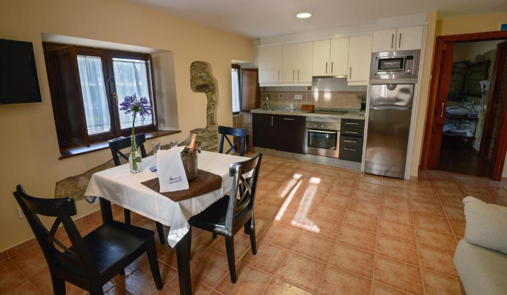 a kitchen with a table and chairs in a room at Casona de Llanorrozo Apartamentos Rurales in Oviñana