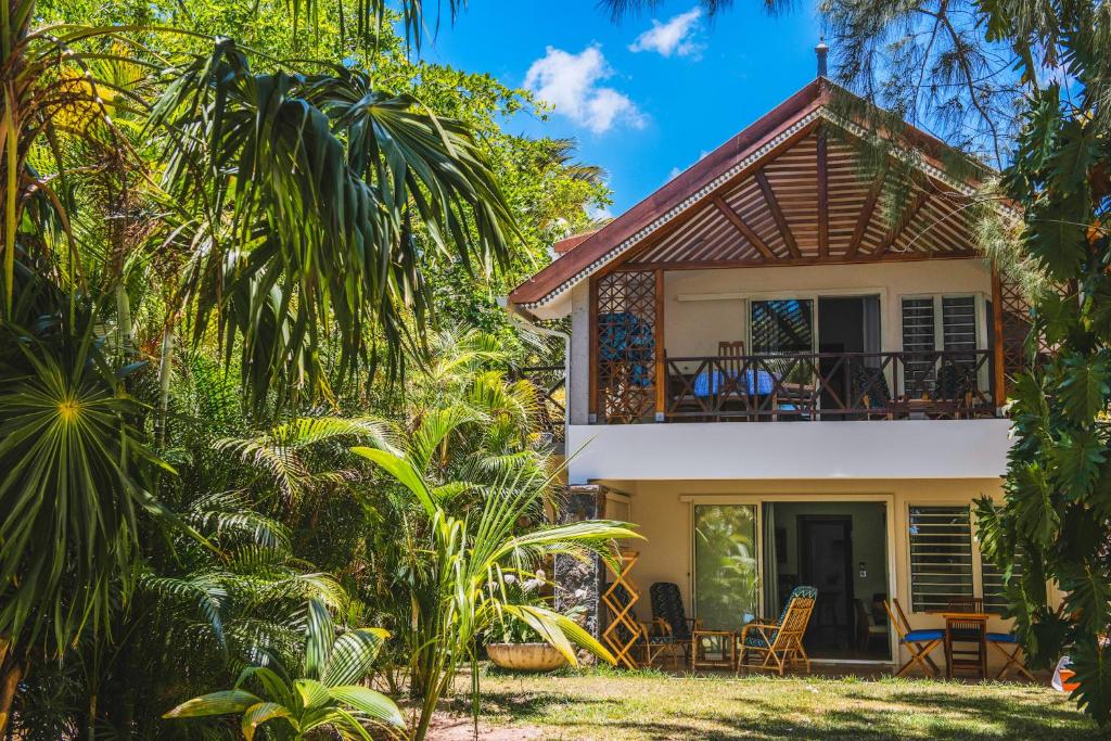 una casa con balcón en medio de árboles en Coconuts, en Grand Baie