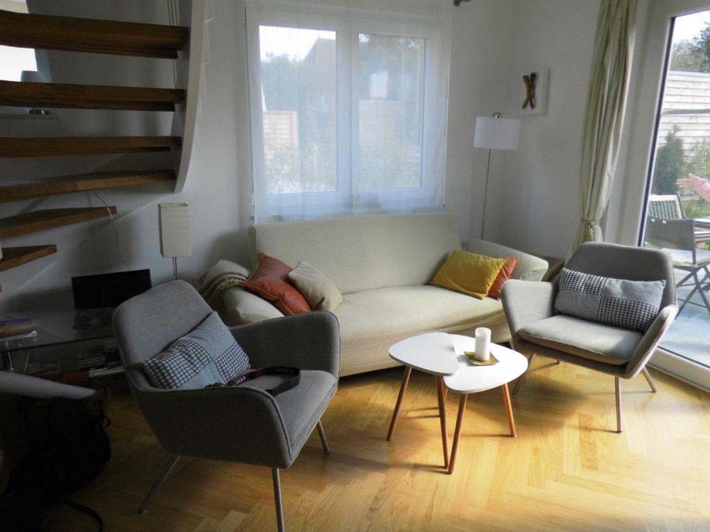 uma sala de estar com um sofá e duas cadeiras e uma mesa em Ferienwohnung Ferienhaus Hohwachter Bucht Ostsee DSL WLAN em Hohwacht