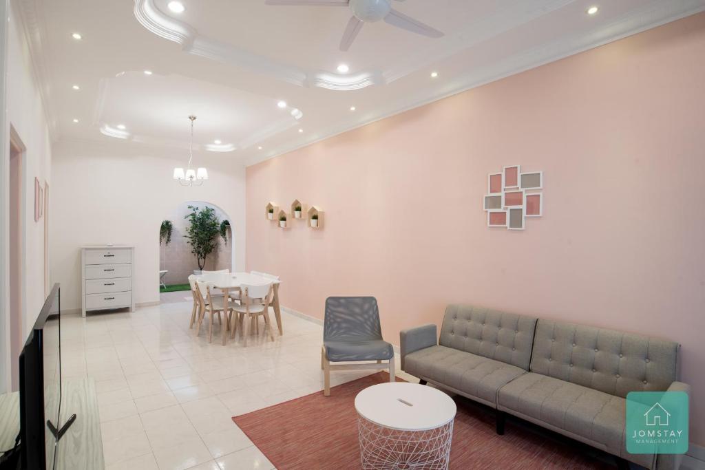 uma sala de estar com um sofá e uma mesa em Jomstay Pink House Ipoh em Ipoh