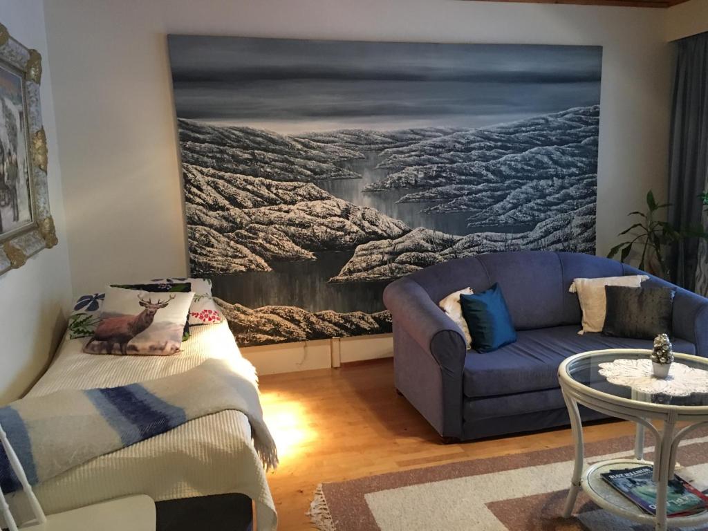 a living room with a couch and a painting on the wall at Arctic Circle Apartment in Rovaniemi