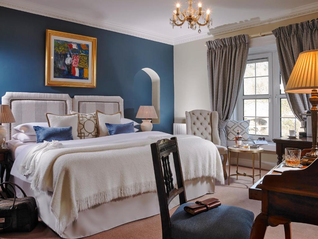 a blue bedroom with two beds and a desk at The Old Bank Town House in Kinsale