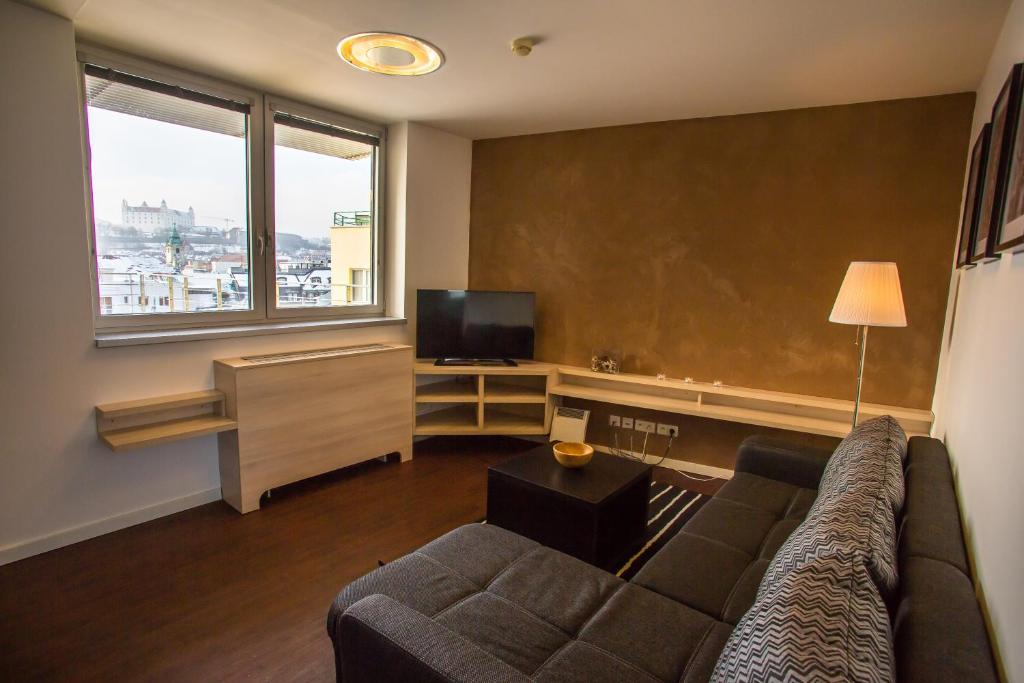 een woonkamer met een bank en een flatscreen-tv bij 22nd Uprising Square in Bratislava