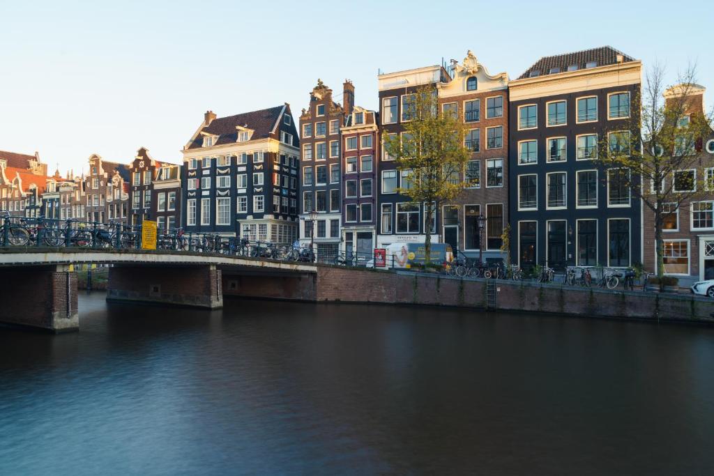 
a bridge over a river near a city at 18th Century Groundfloor Canal House with patio/garden in Amsterdam
