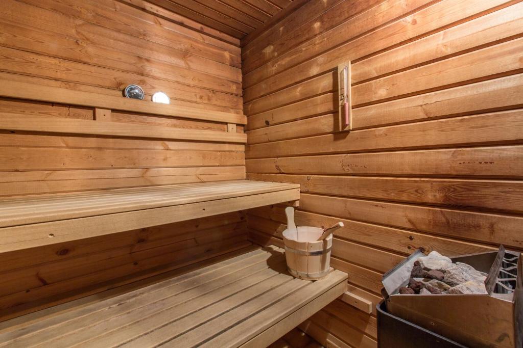 a wooden sauna with a trash can and a bucket at Hotel Les Bruyères in Morzine