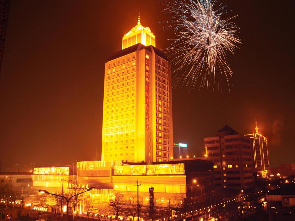 a tall building with fireworks in the city at night at Grand Metropark Wanshi Hotel Taiyuan in Taiyuan