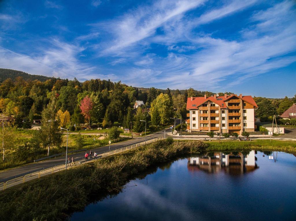 most nad rzeką z budynkiem w tle w obiekcie Apartamenty Bawaria w Szklarskiej Porębie