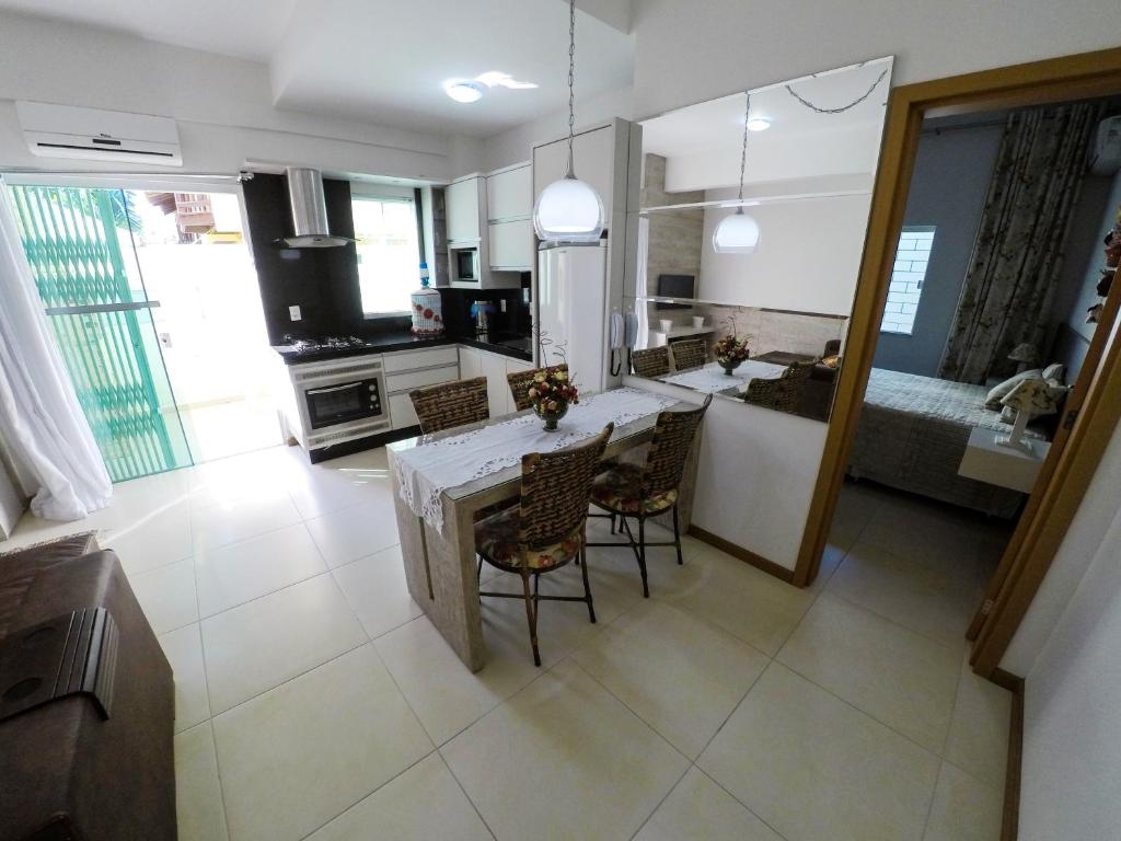 cocina y sala de estar con mesa y sillas en A195 - Ed. Giardino D'Itália, apto térreo, en Bombinhas