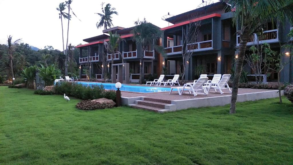 ein Resort mit einem Pool und Stühlen im Hof in der Unterkunft Lanta Infinity Resort - SHA Extra Plus in Ko Lanta