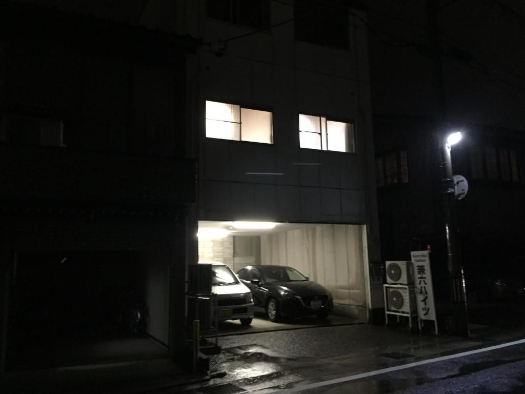 金澤的住宿－兼六高地301號公寓，夜间停在大楼前的汽车