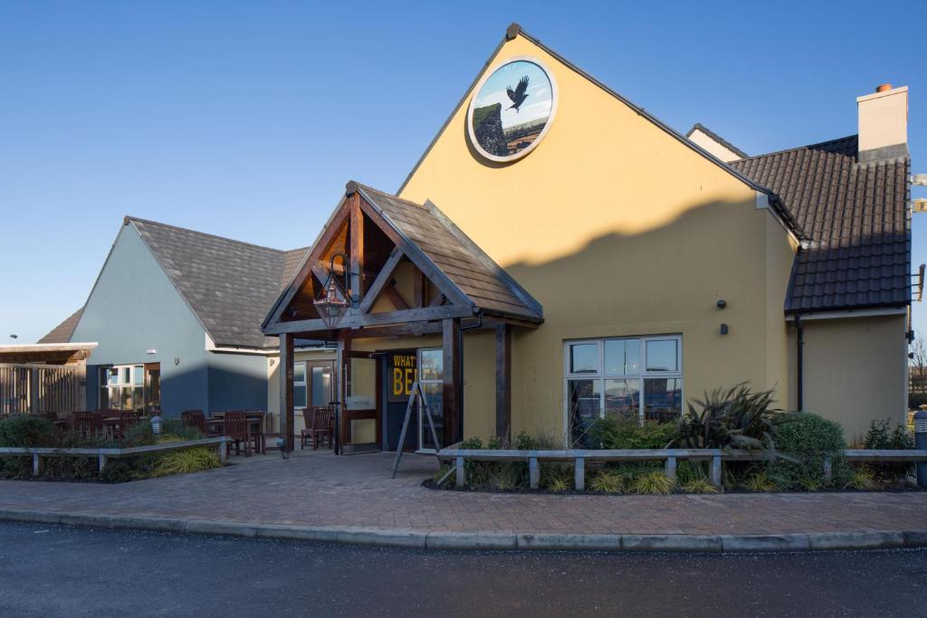 un edificio con un cartel en el costado en The Raven’s Cliff Lodge by Marston's Inns en Motherwell