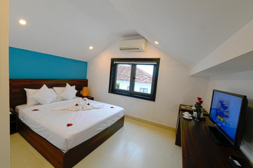 Postel nebo postele na pokoji v ubytování Hoi An Dream City Hotel